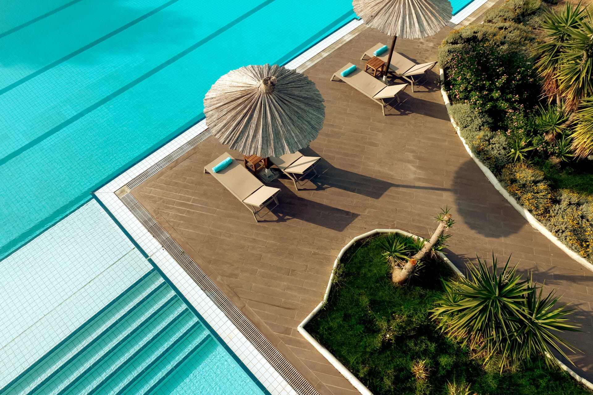 a person sitting on a chair under an umbrella on a beach