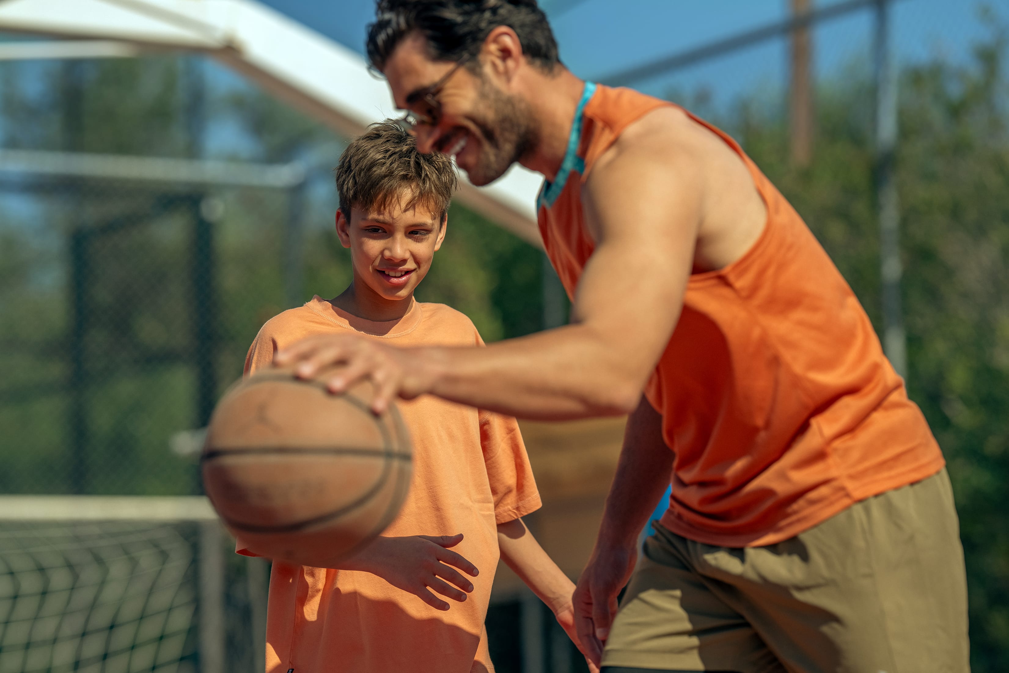 a man holding a basketball and a boy holding a basketball