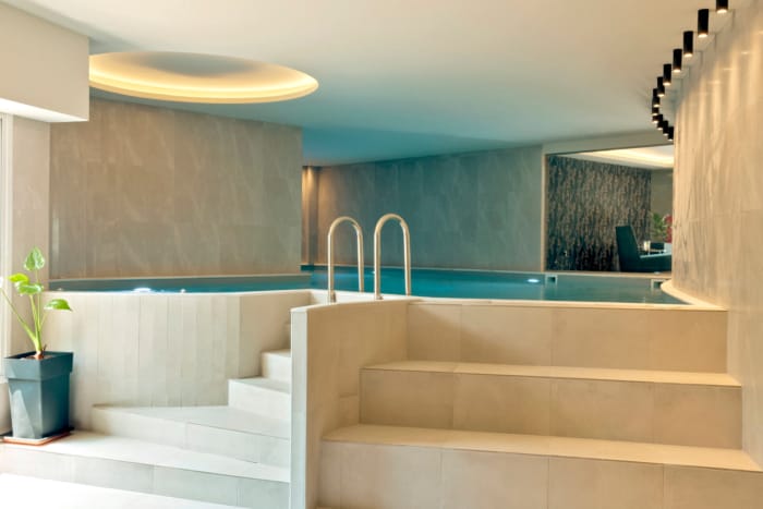 a white bathtub with a blue tile floor and a white wall