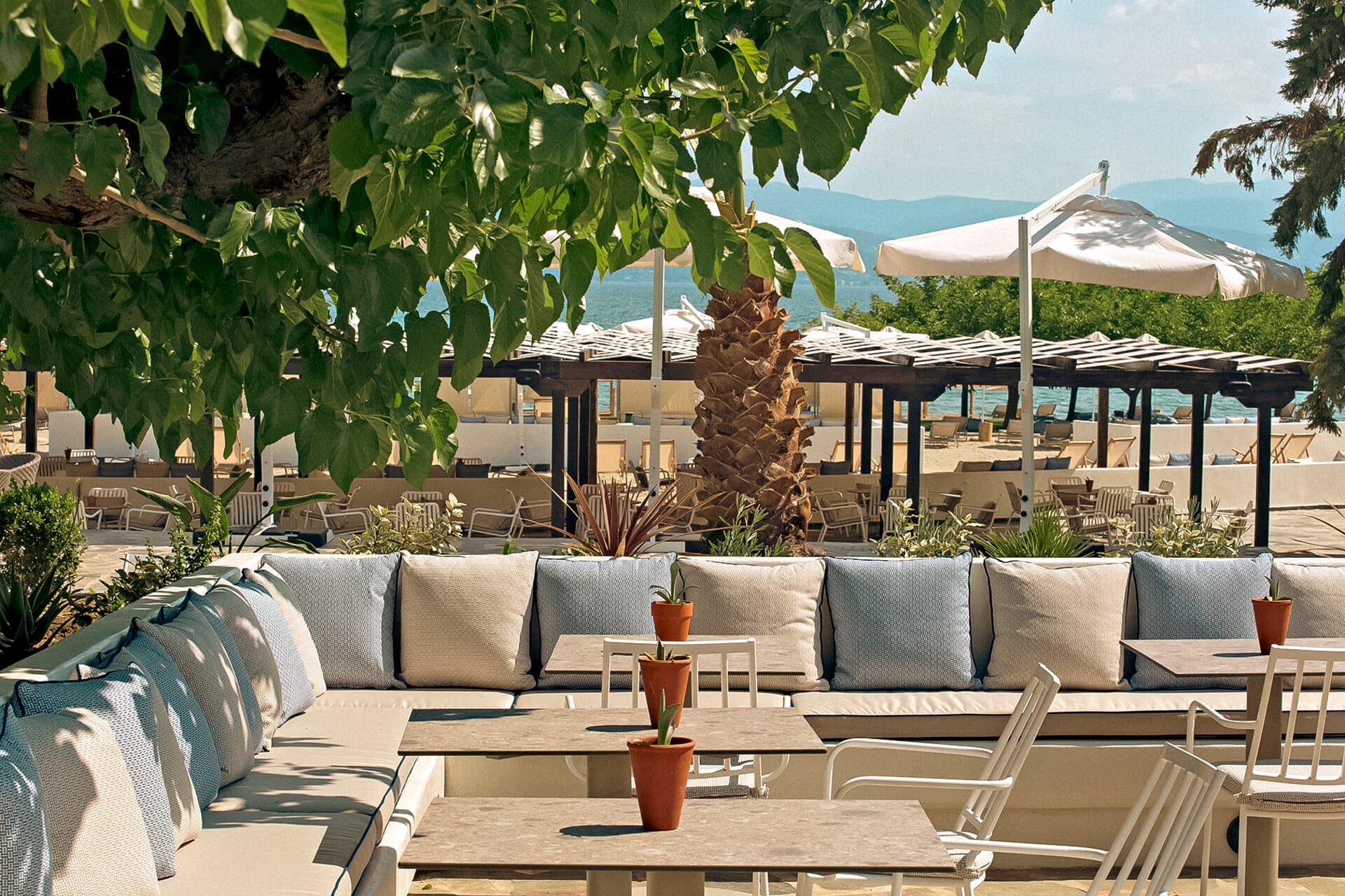 a patio with white chairs and umbrellas