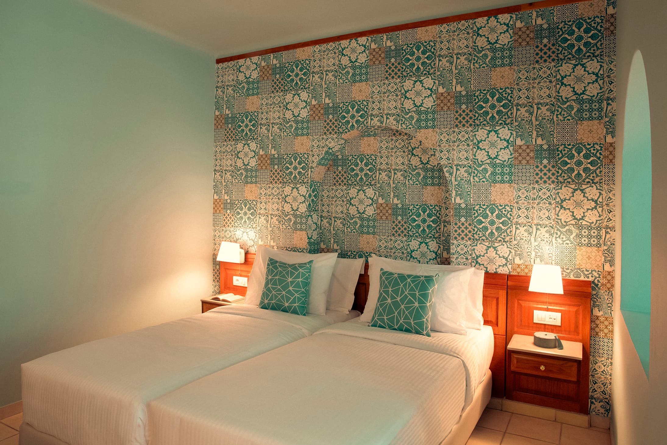 a bed with a flowered wallpaper
