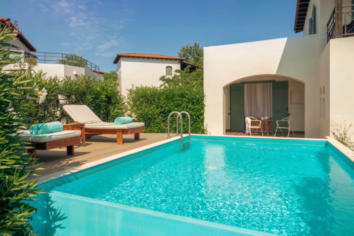 a pool with chairs and tables by it