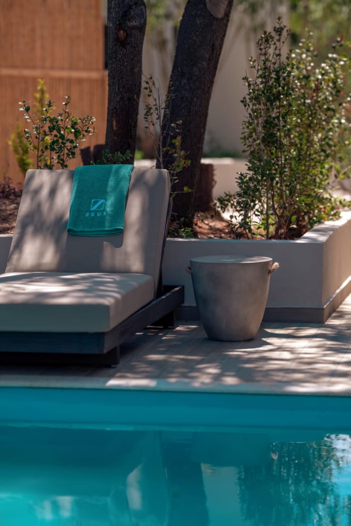 a chair and a pot by a pool