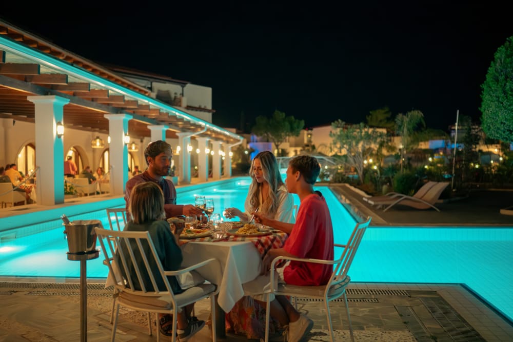 a group of people sitting at a table outside