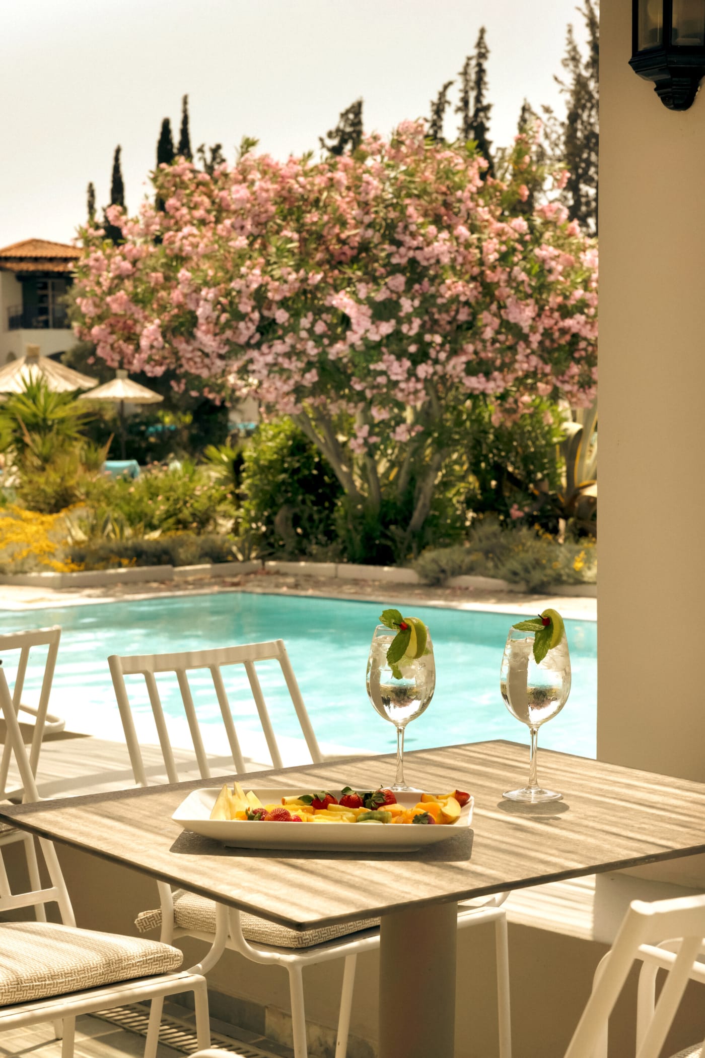 a table with glasses and food on it by a pool