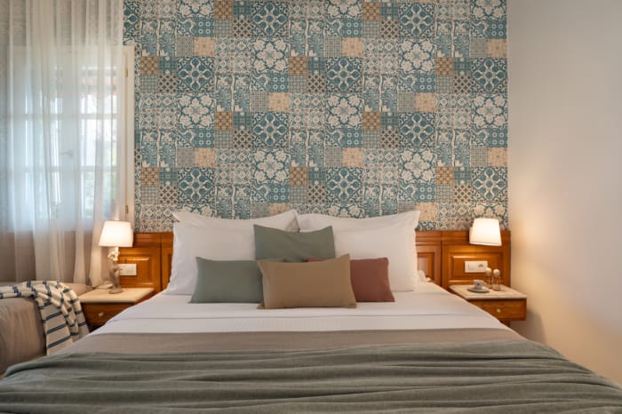 a bed with a floral wallpaper