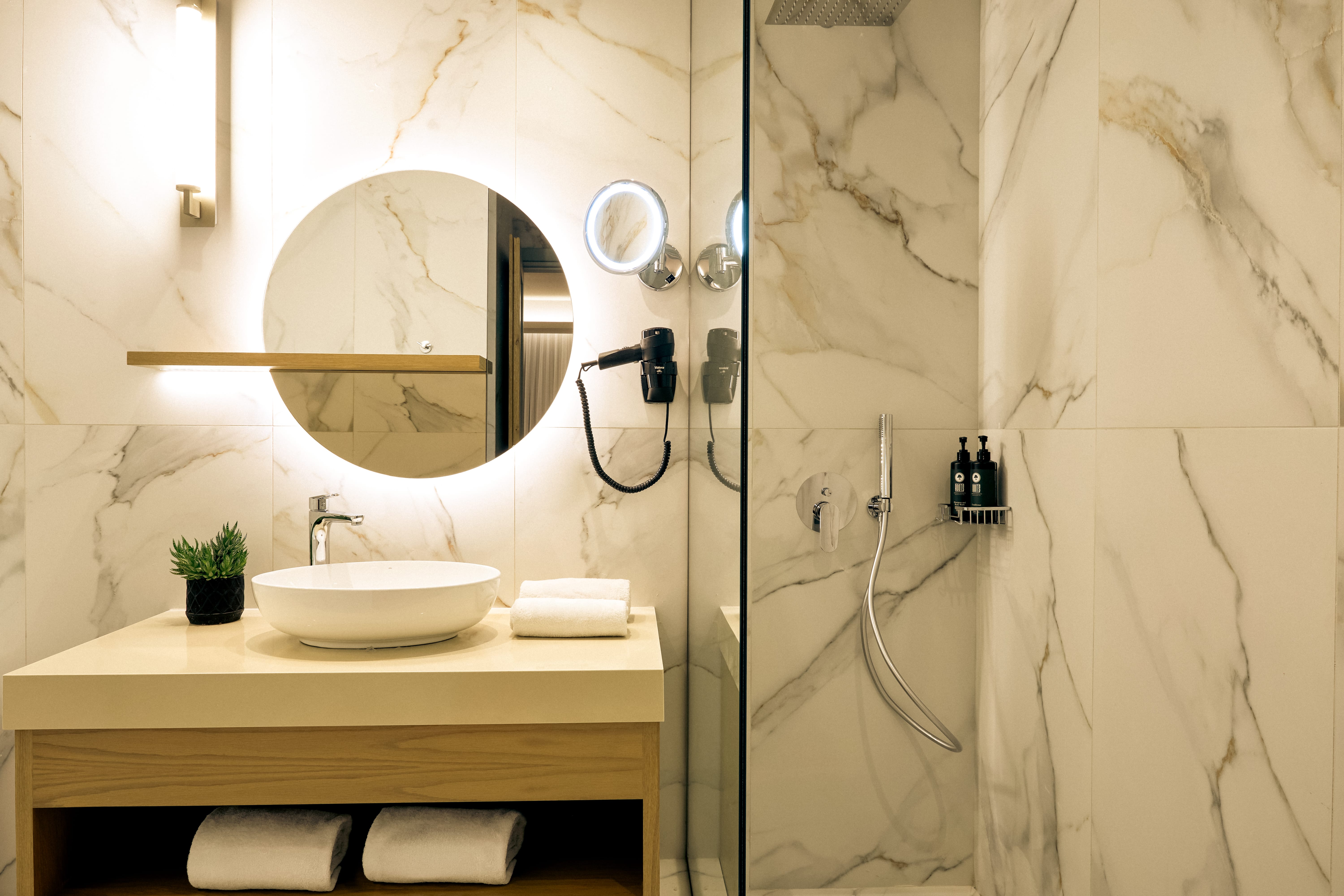 a bathroom with a round mirror and a sink
