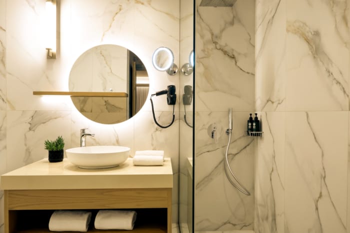 a bathroom with a round mirror and a sink