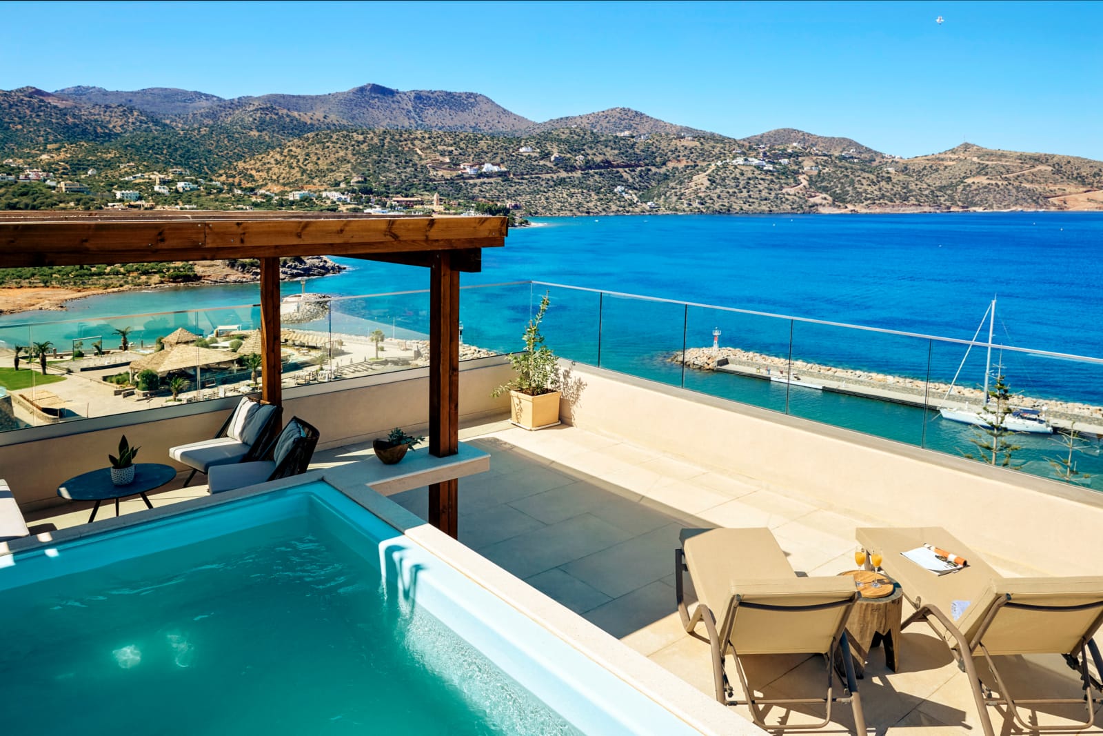 a pool with chairs and a deck overlooking a body of water